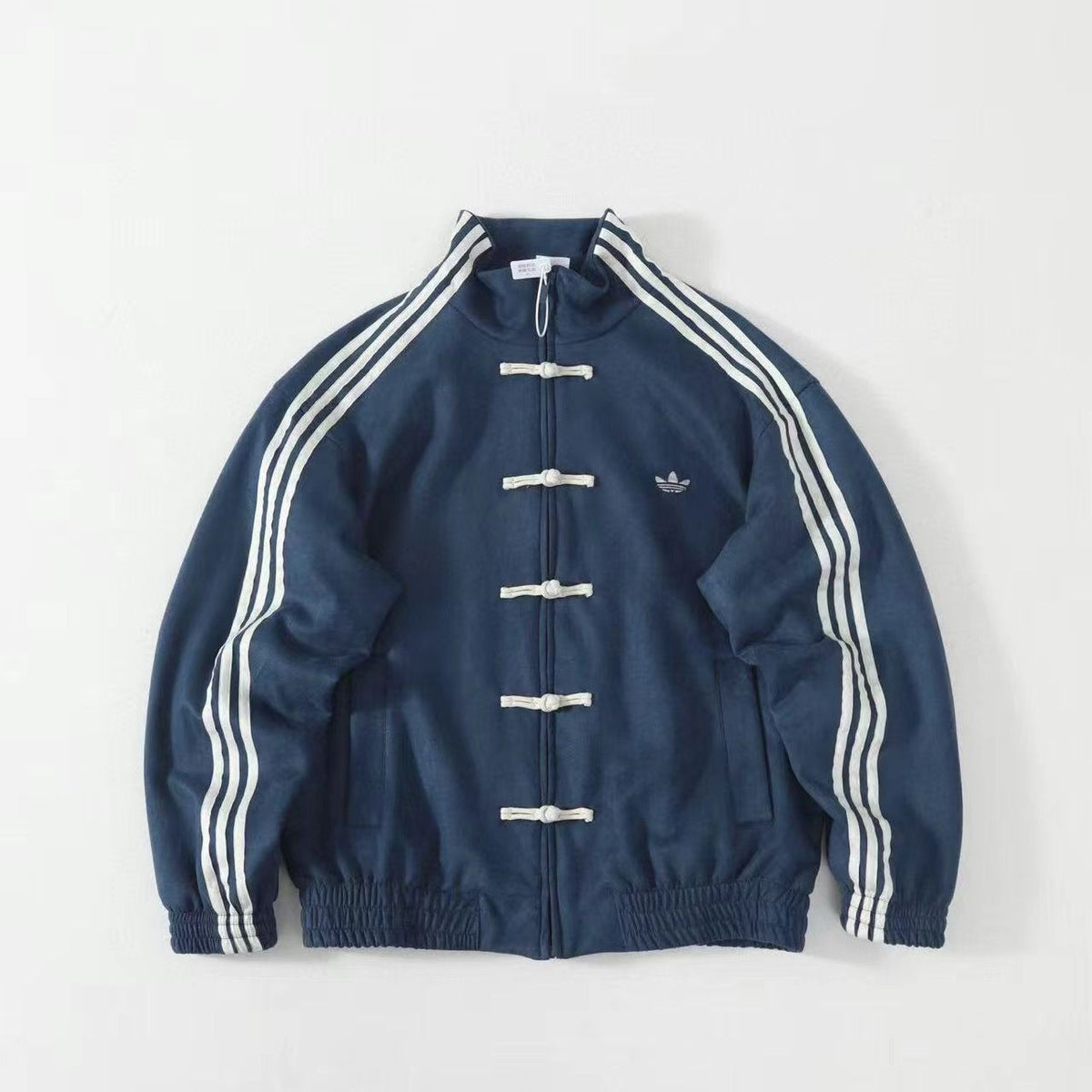 Blue track jacket with white stripes, toggle buttons, and embroidered logo on chest. Chinese New Year Suede Track Jacket – Premium Festive Streetwear