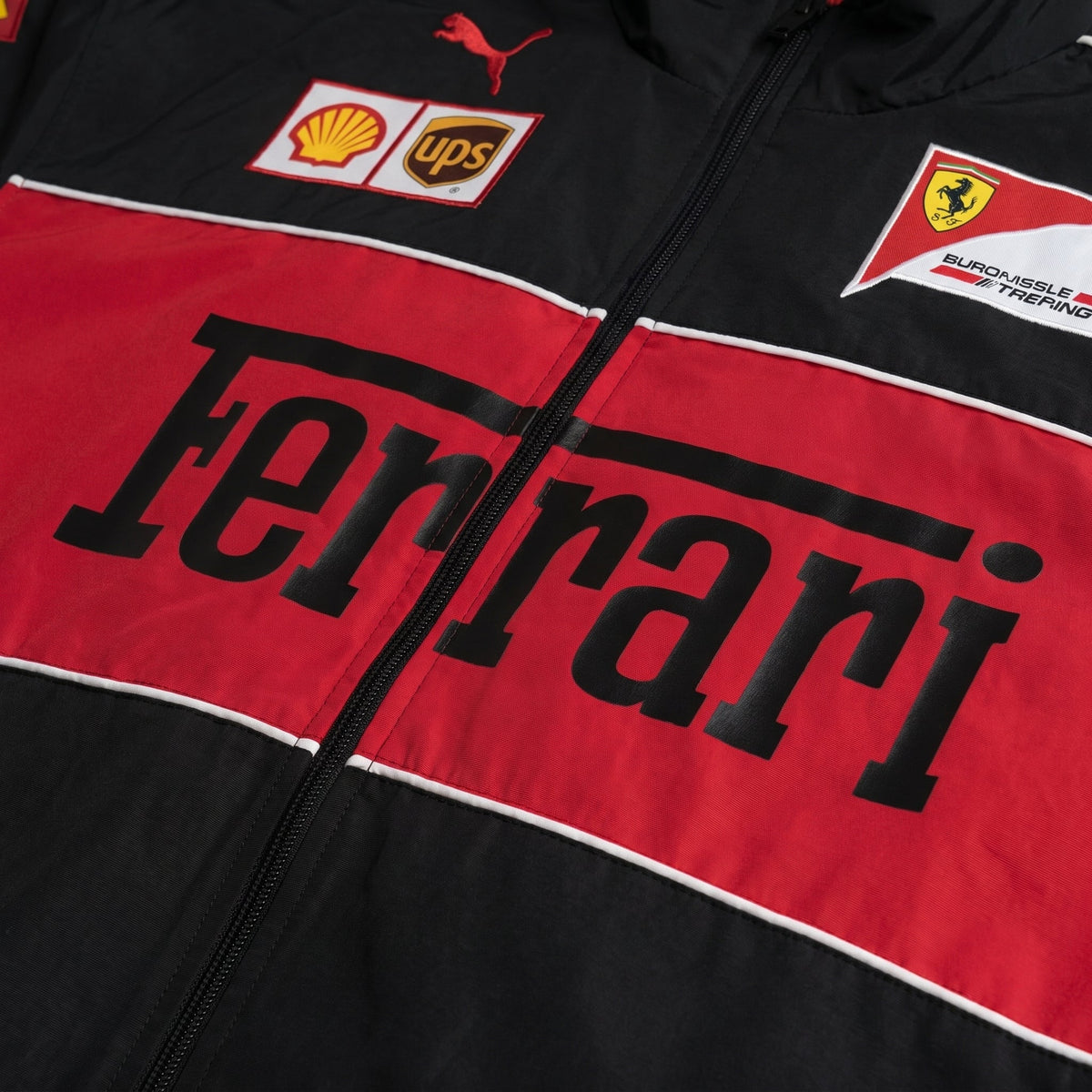 Black and red Ferrari jacket with various logos on a close-up view