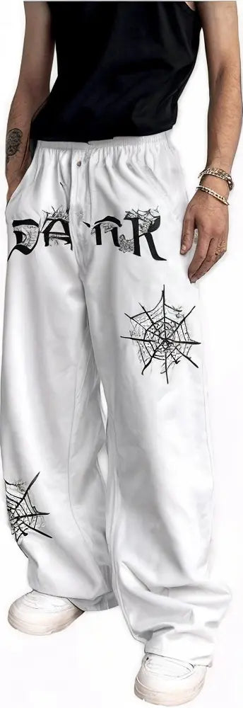 White baggy pants with gothic spider web print and bold black lettering, Gen Z streetwear style.